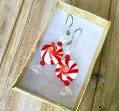 two red and white lollipop earrings in a box