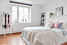 a bedroom with white walls and wooden floors