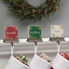 three christmas stockings hanging from hooks on a mantle