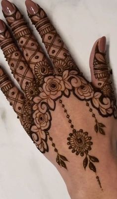 the hand is decorated with henna and flowers