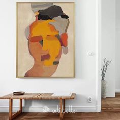 a painting hanging on the wall above a wooden table in a room with white walls