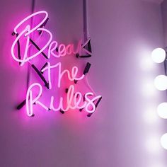 a neon sign that reads,'because the rules are in pink and purple lights