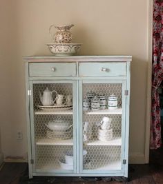 a china cabinet with glass doors and dishes on top