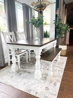 a dining room table with two benches and a potted plant in the center on a rug