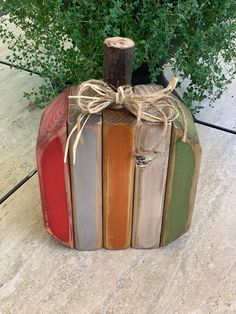 a wooden pumpkin shaped like an apple with a bow on it's head and painted in different colors