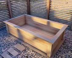 a wooden bench sitting on top of a gravel covered ground