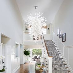 a large white chandelier hanging from the ceiling in a room with hardwood floors