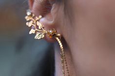 This gorgeous ear cuff is decorated with a variety of leaves and flowers, including one rose and a single swarovsky crystal. It comes with a small leaf stud for the other ear. There are two chains that fall from the lower corner of the cuff and go just beyond the chin level.You only need one piercing at the bottom of the ear in order to wear this ear cuff. The top part of the cuff could easily be adjusted to fit any ear size with a small screw that easily makes it tighter or looser and does not Gold Dangle Ear Cuff For Wedding, Pierced Dangle Ear Cuff For Wedding, Elegant Dangle Ear Cuff For Wedding, Elegant Rose Gold Ear Cuff For Wedding, Adjustable Dangle Ear Cuff For Wedding, Bohemian Ear Cuff For Weddings With Pierced Ears, Rose Gold Ear Cuff For Wedding, Bohemian Single Ear Cuff For Wedding, Bohemian Handmade Ear Cuff For Weddings