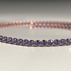 Add a breathtaking touch to your ensemble with this exquisite Tanzanite Tennis Bracelet. Skillfully handcrafted using high-quality 14K/18K gold, this custom stacking bracelet is perfect for everyday wear or special occasions. Adorned with stunning Tanzanite gemstones, this December birthstone bracelet is a must-have for any jewelry lover. It also makes a thoughtful Christmas gift that will surely impress. Don't miss out on our exclusive Cyber Sale and treat yourself or a loved one today!𝐅𝐞𝐚𝐭 Adjustable Blue Round Tennis Bracelet, Formal Tanzanite Round Bracelets, Silver Tanzanite Bracelet Fine Jewelry, Blue Tanzanite Gemstone Bracelets, Luxury Tanzanite Gemstone Bracelet, Stacked Wedding Rings, Tanzanite Gemstone, Band Bracelet, Birthstone Bracelets