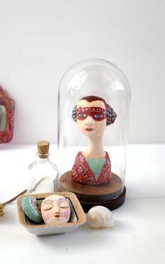 a glass clochet with an image of a woman under it next to other items