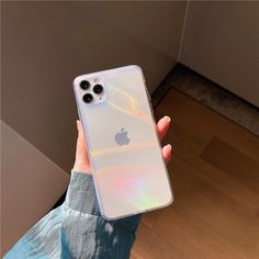 a person holding an iphone case in their hand with the back light reflecting off of it