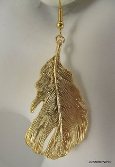 Bold gold feather earrings. You couldn't ask for more! Such detailed, stunning earrings are the perfect accessory for any outfit. Detailed gold plated feathers hang from gold-filled ear wires. The ear wires can be switched out to stainless steel, for those with sensitive ears, or gold plated clip-ons at no additional charge. Simply select your option before adding to your cart. Height from top of ear wire to bottom of feather: approximately 2.75 inches Widest point on wings: 1.0 inch Check the o Gold Feather Earrings For Party, Gold Feathered Jewelry For Parties, Gold Feather Earrings As A Gift, Gold Feather Earrings For Gift, Gold Feather Earrings, Angel Earrings, Natural Jewelry, Gold Feathers, Stunning Earrings