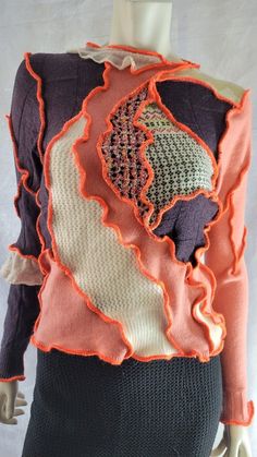 a mannequin wearing an orange and black sweater with ruffles on it