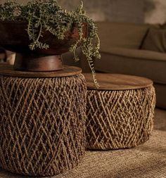 two woven stools sitting on top of a carpeted floor next to a couch