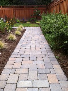 a brick walkway in the middle of a garden