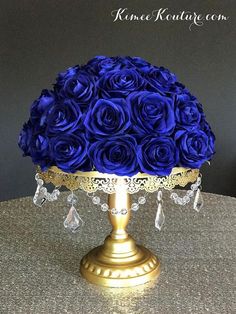 a blue rose covered cake on a gold plate with crystal beads and bead trim