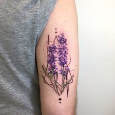 a purple flower tattoo on the left upper arm and shoulder with geometric shapes around it