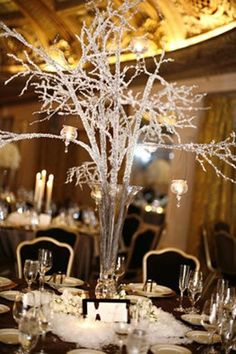 an image of a table setting with white flowers and branches in the center, on instagram