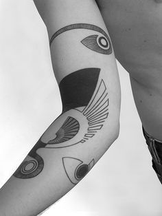 a man's arm with tattoos on it and an arrow in the middle,