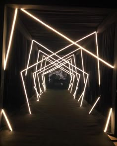 an illuminated tunnel in the dark with white lights