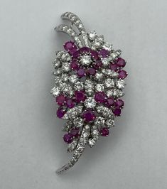 Showcase your style with this stunning pre-owned Estate Art-Nouveau Style Brooch. Crafted with 18k White Gold (16.20 grams), this brooch features a beautiful combination of Diamond and Ruby stones that add a touch of elegance to any outfit.  Featured are 79 natural round brilliant whitediamonds (VS2-I1 range of quality) with a total carat weight of 4.50 ctw along with 25 purplish red rubies amounting to a total carat weight of 3.75 ctw. The brooch is accompanied by an EGLUSA Report that verifies the stones. This brooch is perfect for anyone who loves fine jewelry and wants to add a touch of luxury to their collection. With its exquisite design and exceptional quality, this brooch is sure to become a treasured possession for years to come. Condition:  This item is pre-owned and shows signs Elegant Multi-stone Collectible Brooches, Elegant Diamond Multi-stone Brooch, Elegant Multi-stone Brooches For Formal Occasions, Gold Brooch, Ruby Stone, Gold Brooches, Exquisite Design, Round Brilliant, Art Nouveau