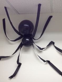 a black spider sculpture sitting on top of a white table