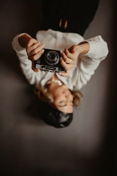 two people holding up a camera in front of their faces to take a selfie