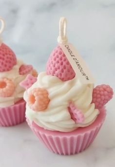 three cupcakes decorated with pink and white frosting