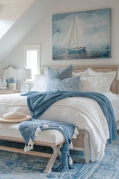 a white bed sitting under a window next to a blue rug