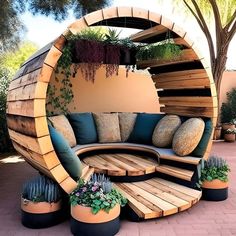 an outdoor seating area made out of wooden planks with plants growing in the center