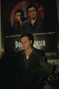 a man standing in front of a movie poster