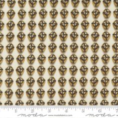 an image of gold and white wallpaper with small circles in the center, on a ruler