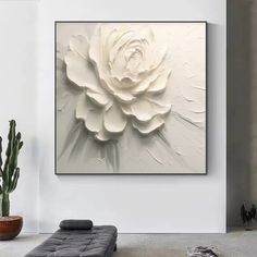 a large white flower is hanging on the wall