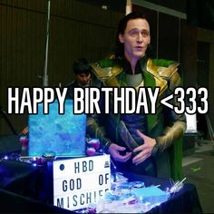 a man dressed as loki in front of a table with a sign that says happy birthday