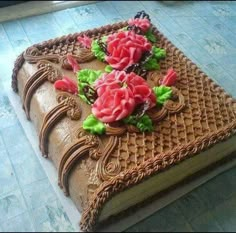 a large chocolate cake with flowers on it's cover is sitting on the floor