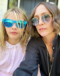 two women sitting next to each other wearing sunglasses