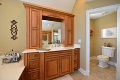 a large bathroom with wooden cabinets and white toilet