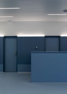 an empty room with blue walls and doors