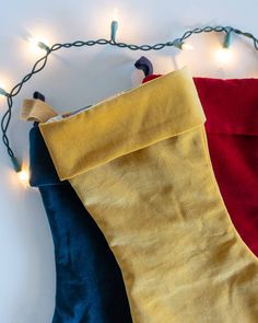 two christmas stockings hanging from a string with lights on them, one red and one blue