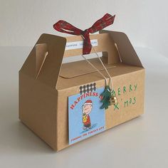 a cardboard box with a card inside and a bow tied around the top that is attached to it