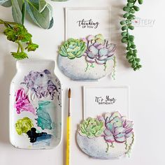 three succulents painted on ceramic dishes next to a pencil and planter