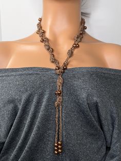 Discover elegance with our handcrafted glass pearl crochet bubble stitch beaded necklace. This unique piece combines the intricacy of crochet with the beauty of glass pearls, creating a stunning accessory perfect for any occasion. The bubble stitch technique adds texture and dimension, making this necklace a standout choice for bohemian and chic style lovers. Whether you're dressing up for a special event or adding flair to your everyday outfit, this necklace is designed to impress. Treat yourself or gift it to a loved one to add a touch of artisanal charm to any jewelry collection. This simple design has a blend of elegance and boho chic that makes it easy to dress up or down for any occasion. Measuring 60 inches this beautiful crochet necklace is a wraparound tie-on necklace, great for w Adjustable Crochet Jewelry For Festivals, Adjustable Macrame Necklaces, Bohemian Brown Crochet Jewelry, Brown Bohemian Crochet Jewelry, Adjustable Crochet Necklace For Festivals, Adjustable Crochet Beaded Necklace For Festivals, Adjustable Crochet Necklaces For Festivals, Artisan Macrame Jewelry, Brown Hand Knotted Jewelry For Gift