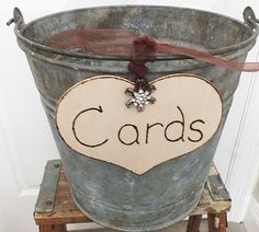 a metal bucket with a sign that says cards in the shape of a heart on it