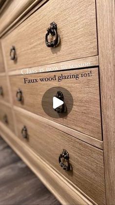 a close up of a wooden dresser with metal knobs and an inscription on the drawer