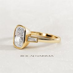 a yellow gold ring with an oval cut diamond and baguets on the side