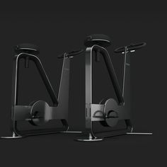 two exercise machines sitting side by side on a black background