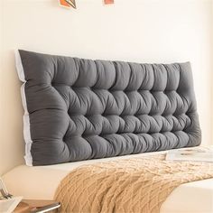 a bed headboard made out of grey fabric