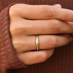 a woman's hand with a gold ring on it