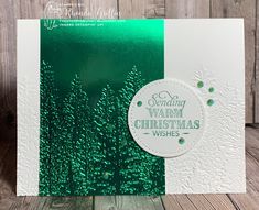 a green and white christmas card sitting on top of a wooden table