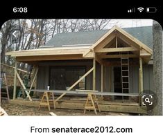 a house being built in the woods with wooden steps leading up to it's front door